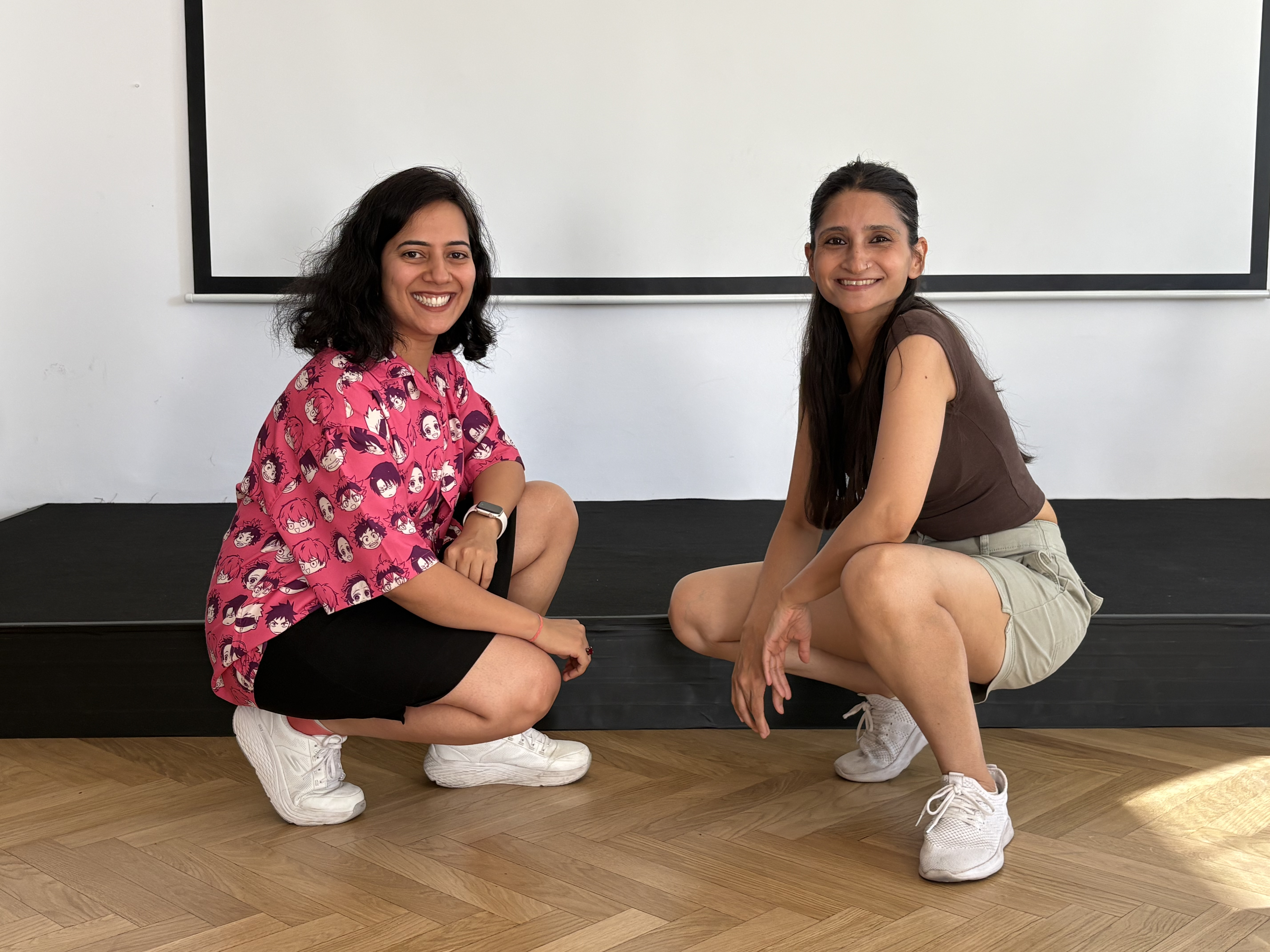 Two participants smiling during a Bollywood fitness class in a studio