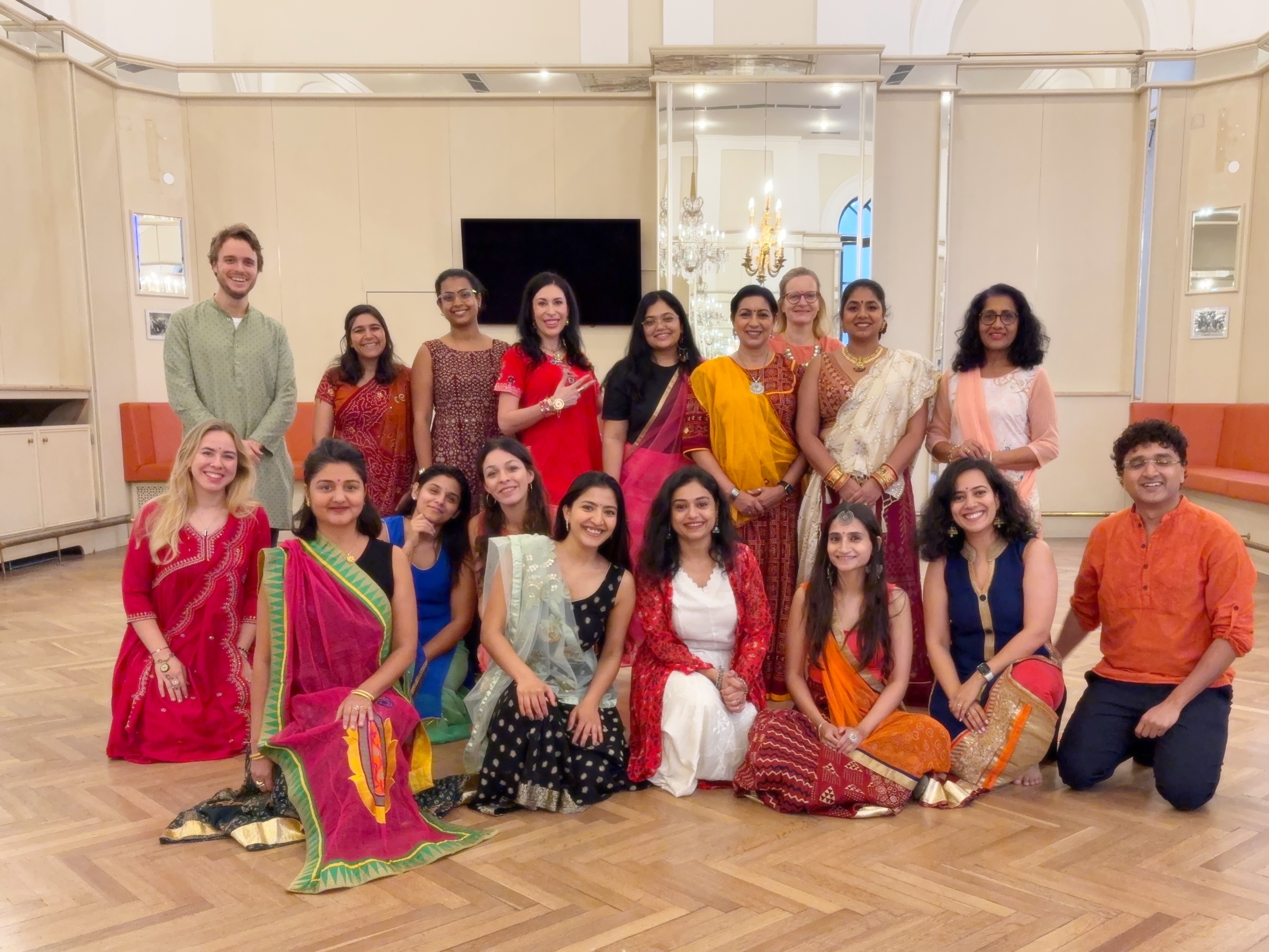 Bollywood Garba workshop participants in colorful traditional clothing holding dandiya sticks